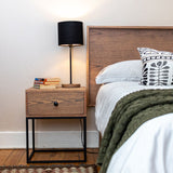 Bedside table with drawer next to bed